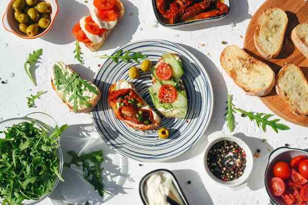 Table set with a variety of colorful vegetables, grains, and simple dishes